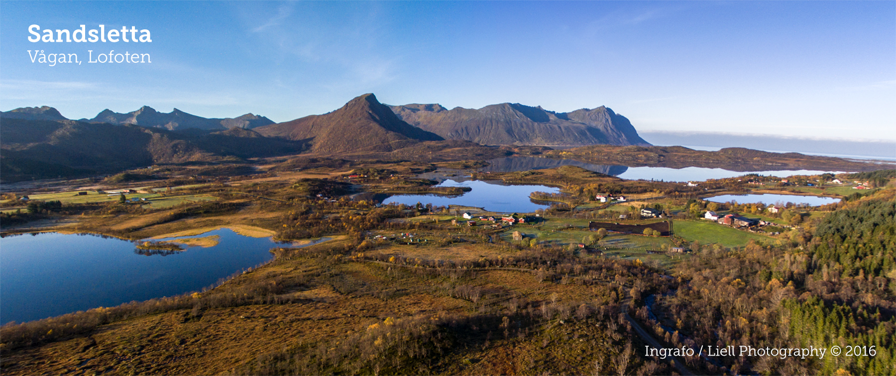 Aerial autumn panorama of Sandsletta wetlands, farms and Lofoten peaks under clear sky