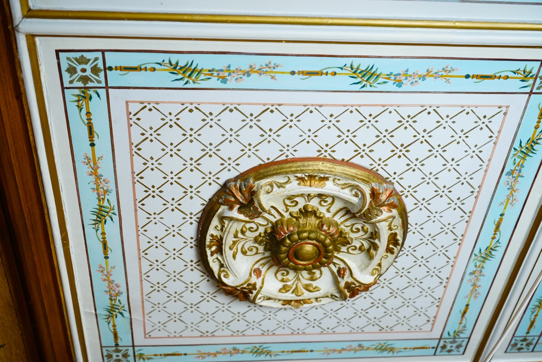 Hand-painted heritage ceiling rosette with gilded plaster ornament and pastel florals