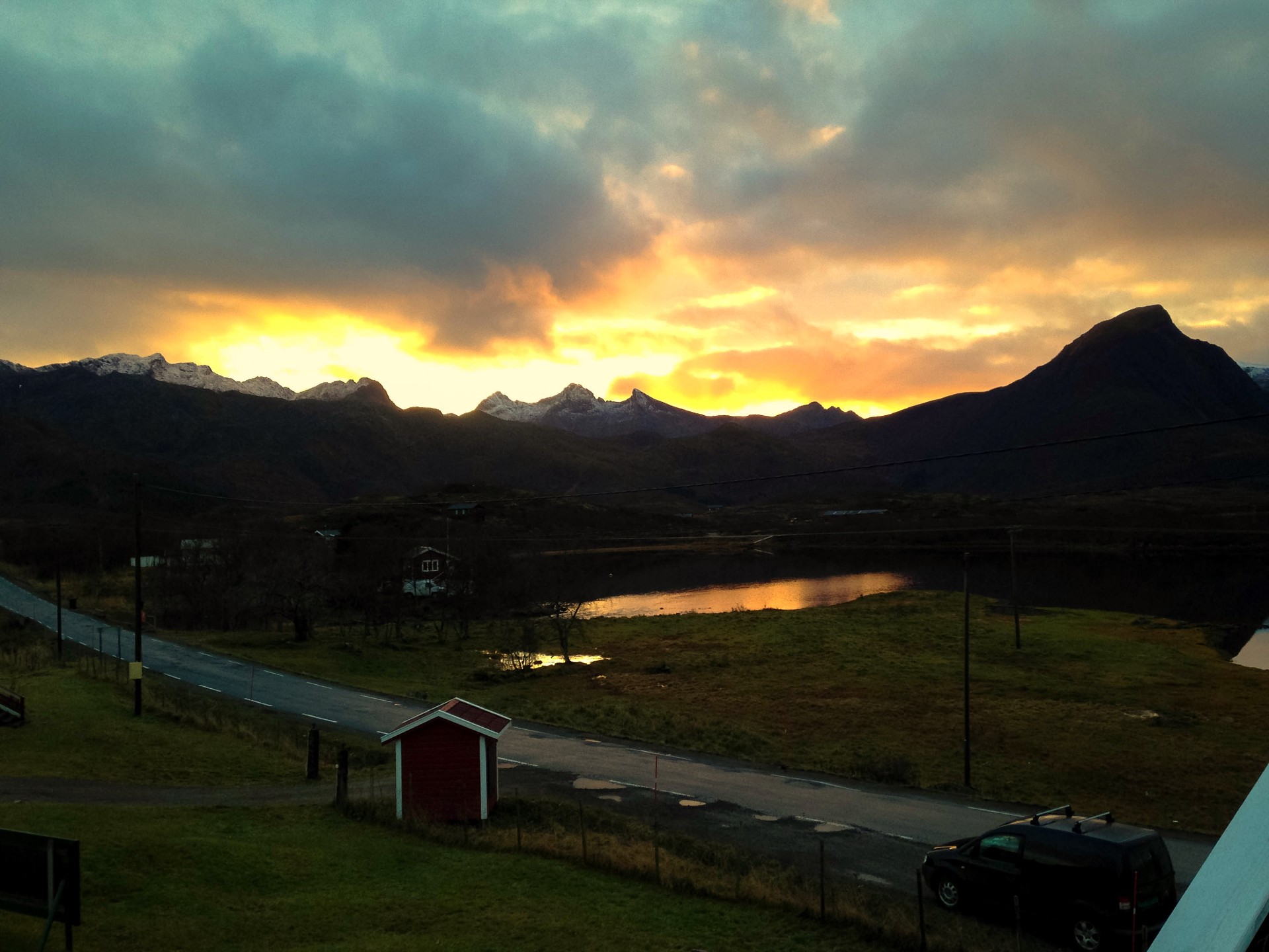 Autumn valley and dark mountains lit by a dramatic golden break in the clouds