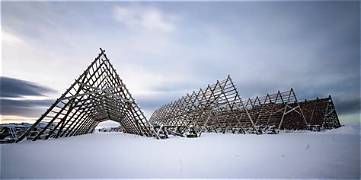 Snow-covered stockfish drying racks at Hjellan in Laukvik under a pale winter sky