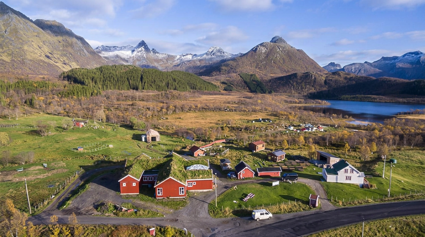 Aerial autumn view of Livland Gård, its red farm buildings, lake and surrounding Lofoten mountains